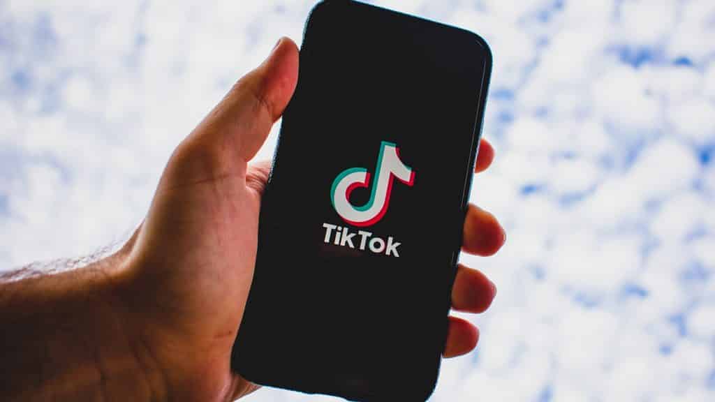 Teléfono con el logo de TikTok frente a las nubes